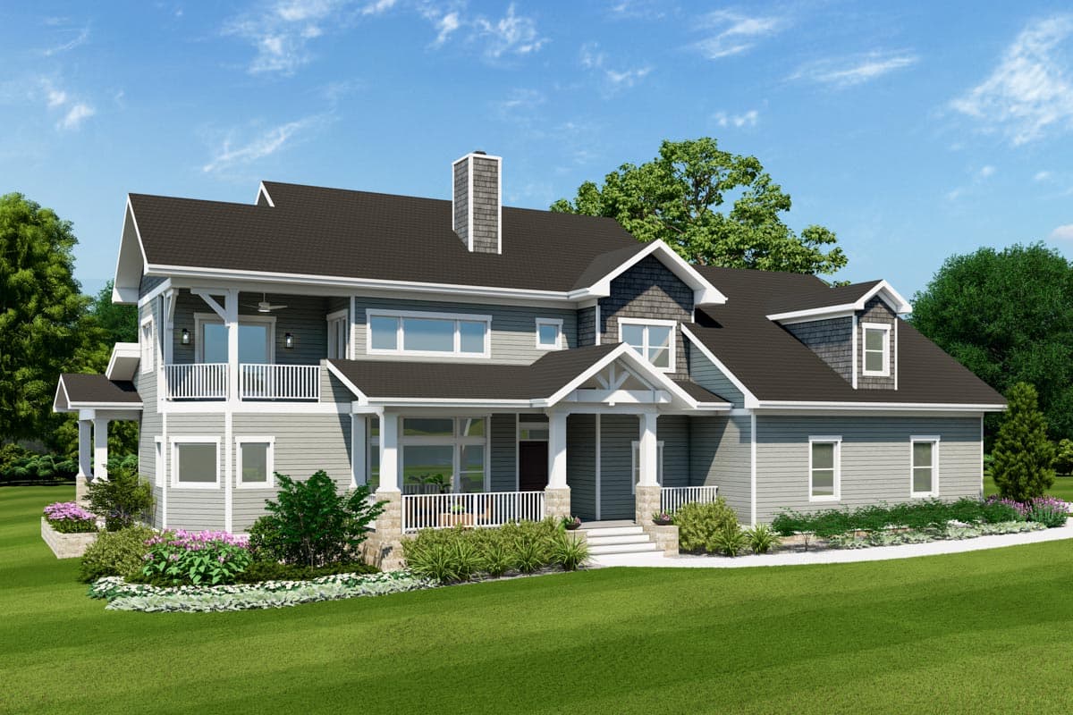 House plan exterior: Two-story home with front porch, wraparound deck, dormers, and stone foundation.