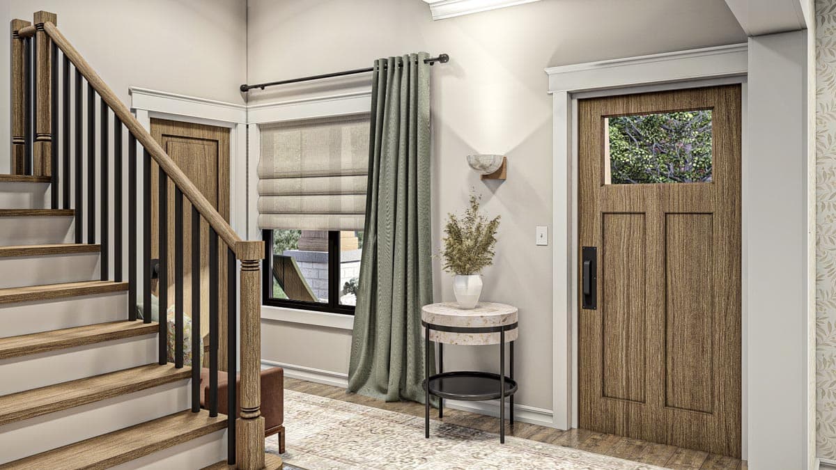 Interior view of a house entrance with wood staircase, wood door with window, and window with green curtains.