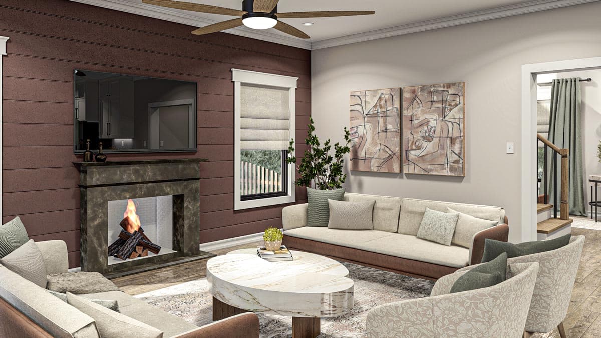 Living room interior with fireplace, sectional sofa, armchairs, marble coffee table, ceiling fan, and stairs leading to upper level.