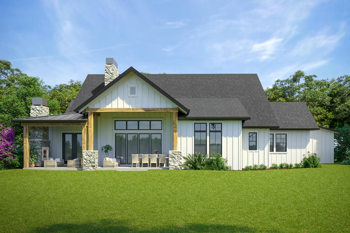 Modern Farmhouse house plan exterior with large stone chimney, covered porch, and expansive glass doors.