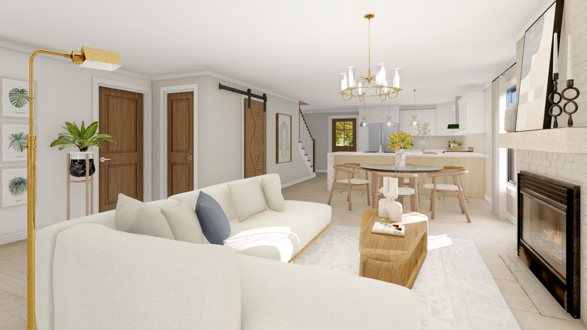 Open-concept living area with sectional sofa, dining table, kitchen island, barn door, fireplace, and stairs.