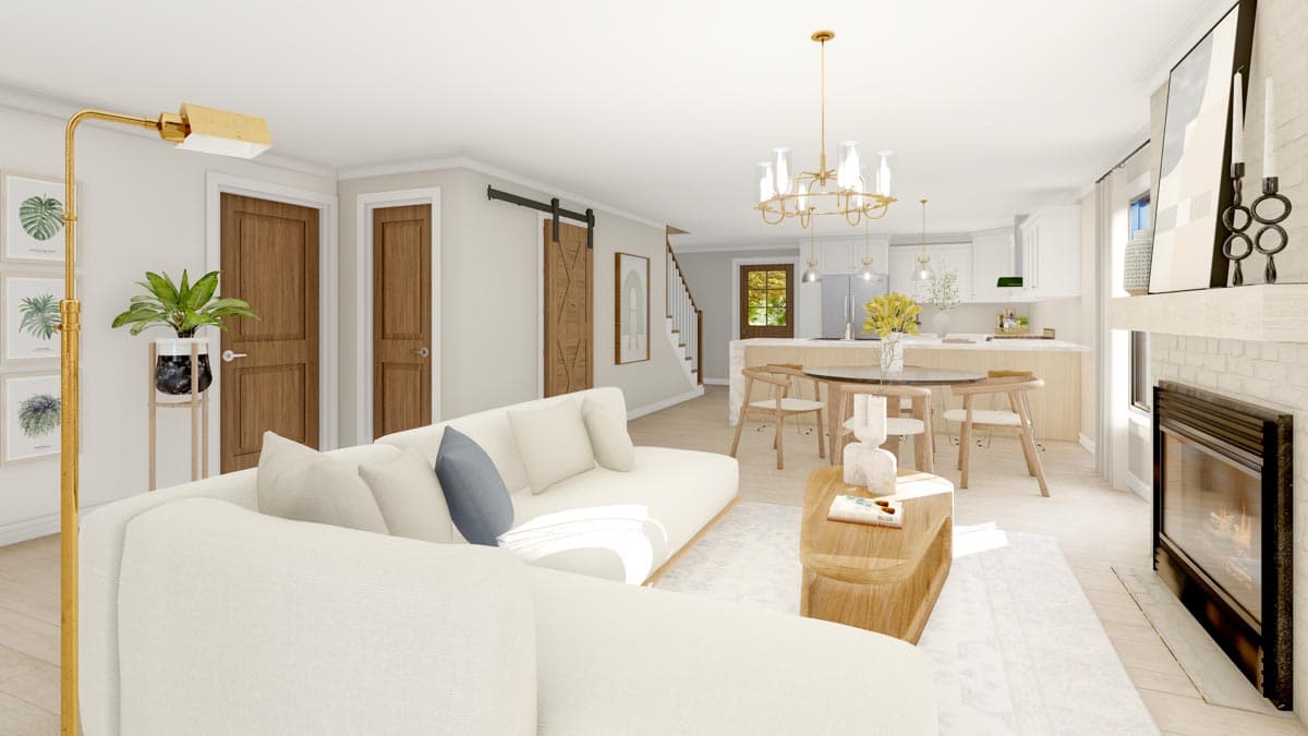 Open concept living area with sectional sofa, dining table, kitchen island, and fireplace. Features barn door and stairs.