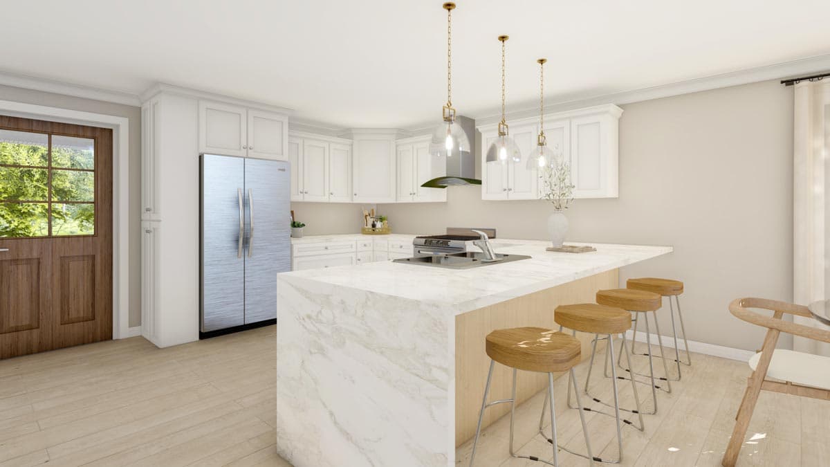 Kitchen interior with white cabinets, stainless steel refrigerator, island with sink, and pendant lighting.