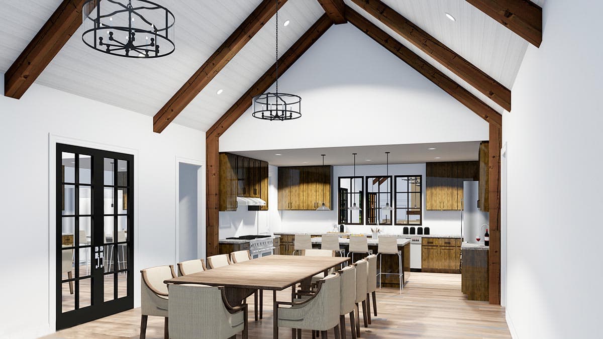 Open concept dining and kitchen with vaulted ceiling, exposed beams, large island, and double doors.