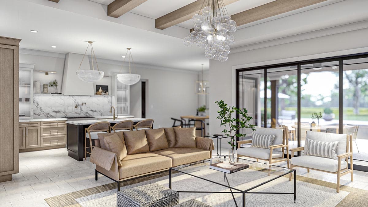 Open concept living area with kitchen island, neutral sofas, and large sliding glass doors leading outdoors.