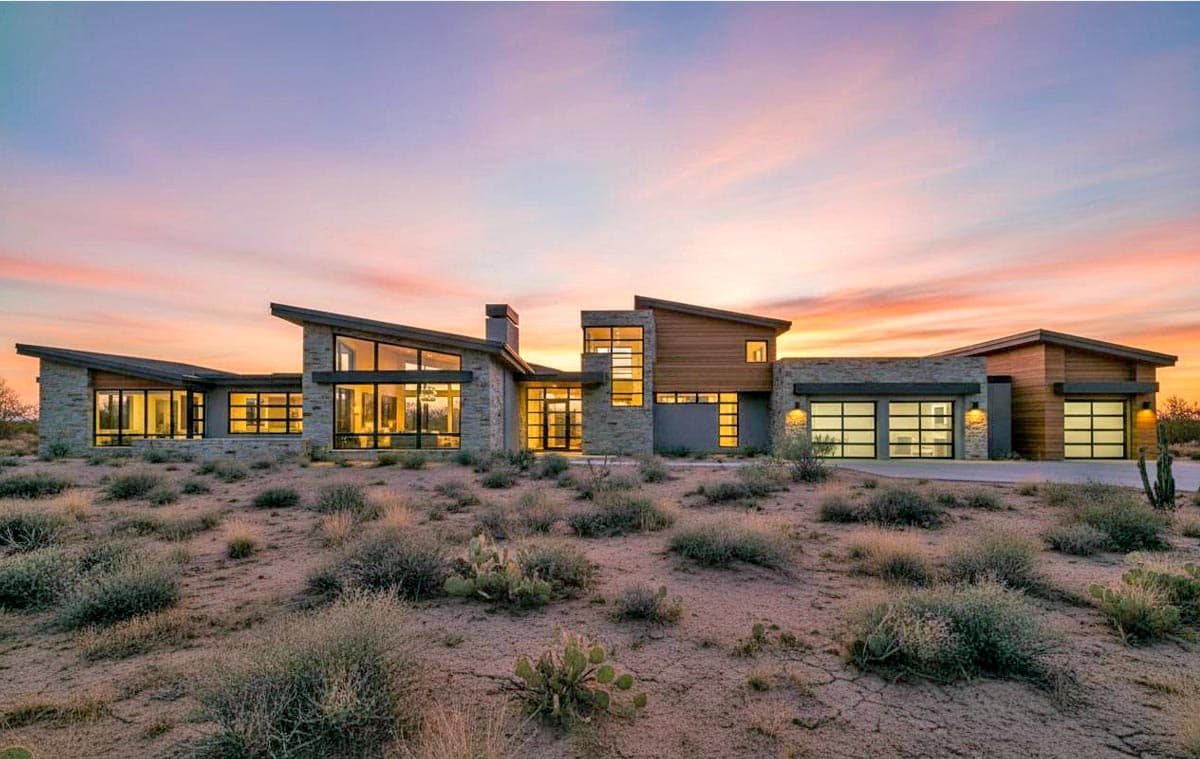 Modern house plan exterior with stone and wood accents, extensive glazing, and multiple garage doors.