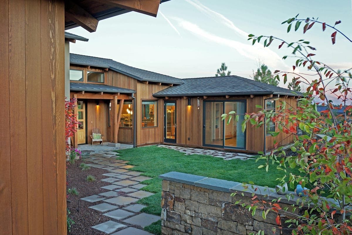 House plan exterior with wood siding, gabled rooflines, covered entry, and large windows.