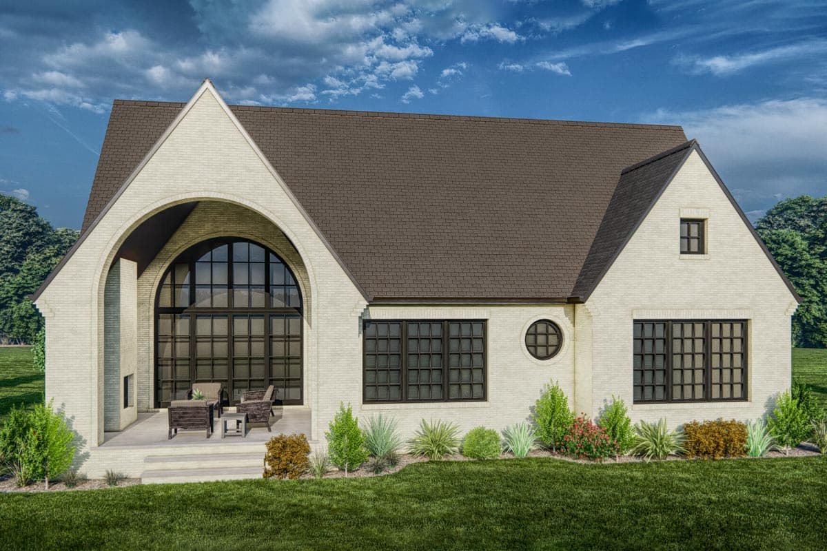House plan exterior featuring white brick, a large arched window, gabled roof, and covered porch.