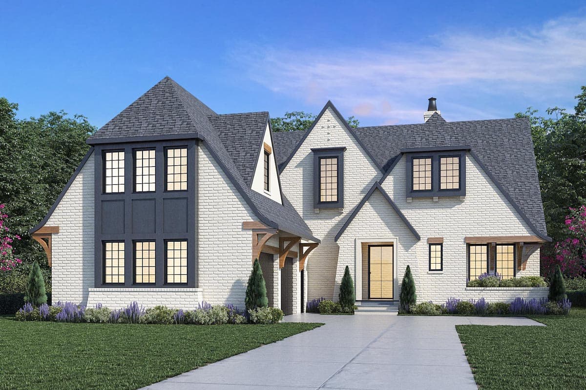 House plan exterior featuring brick facade, multiple gables, and a porte-cochère. Two-story house with dormers and large, multi-pane windows.