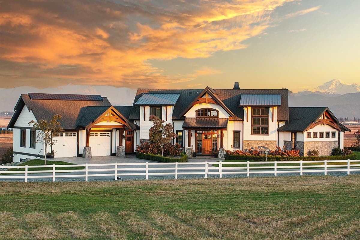 House plan exterior. Modern farmhouse style with gabled roofs, a covered porch, and a detached garage with stone accents. Two stories.