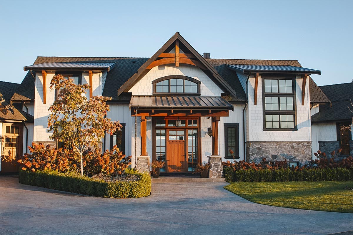 House plan exterior featuring a covered entry with wood beams, stone and shingle siding, dormers, and multiple gables.