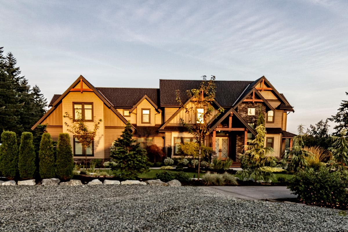 House plan exterior featuring a two-story Modern Farmhouse design with prominent gables, exposed wood beams, and stone accents.