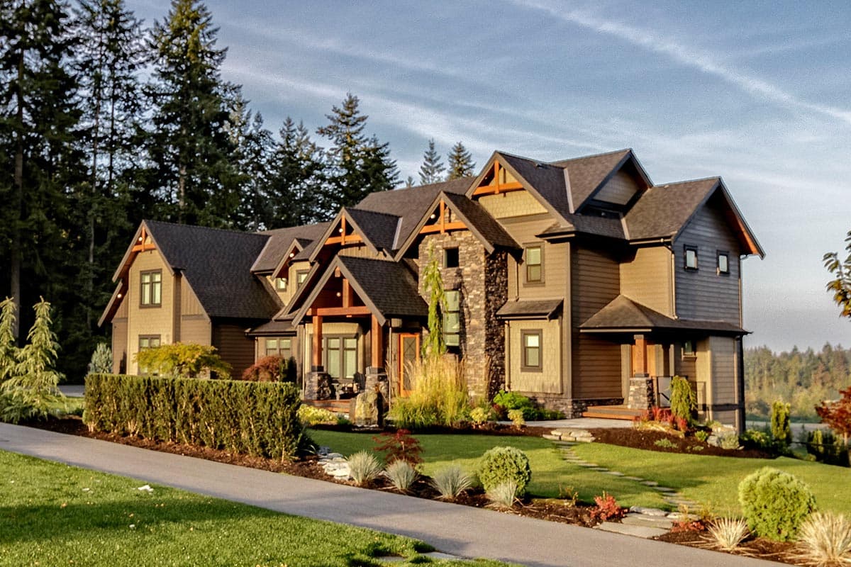 House plan exterior shows a multi-story home with a complex roofline, prominent gables, stone accents, and covered entryways.