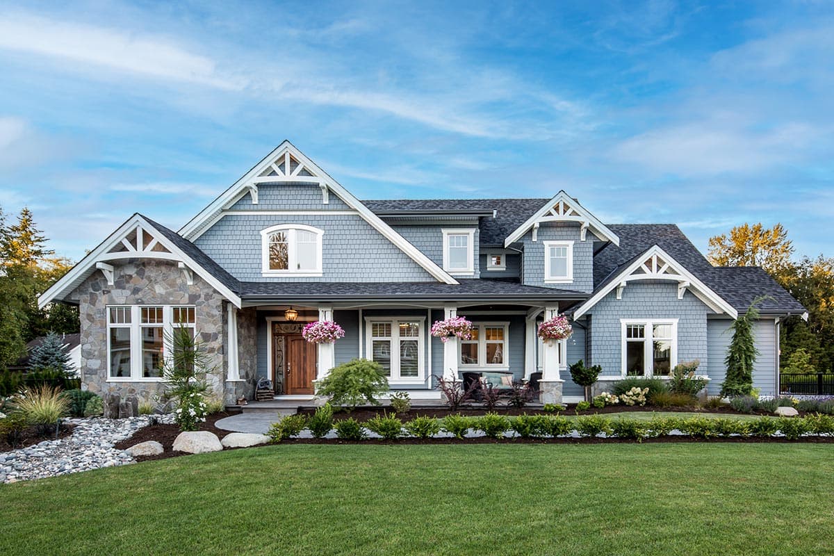 House plan exterior. Craftsman style, two-story house with gabled roof, stone facade accents, and covered porch.