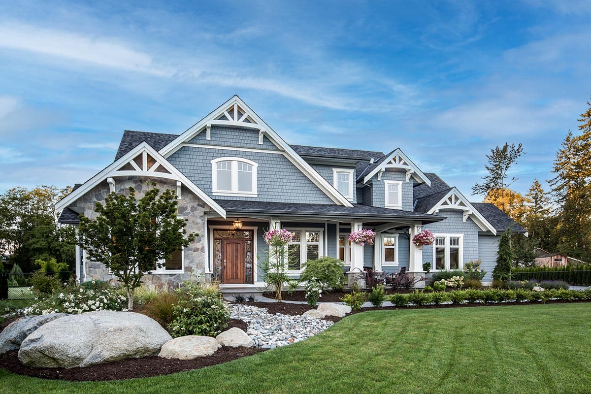 Craftsman style house plan exterior with stone accents, gables, dormers, and a covered front porch.
