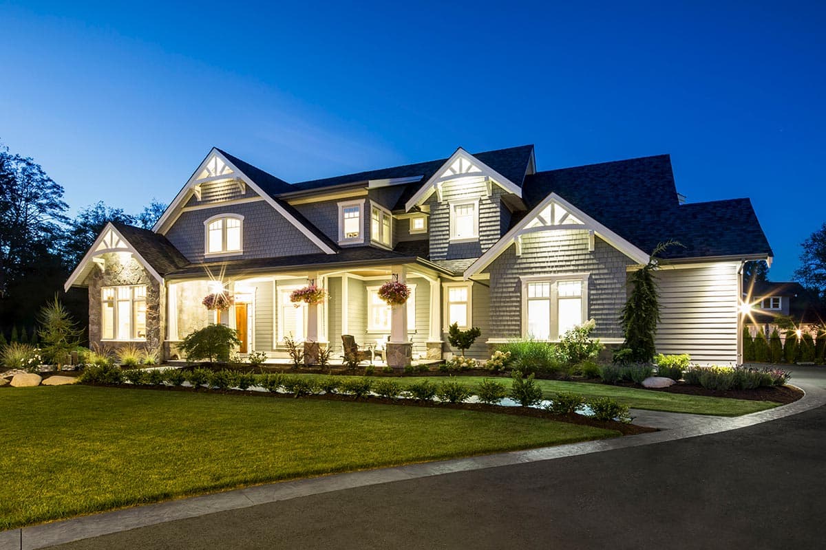 House plan exterior: two-story Craftsman home with prominent gables, stone accents, deep porch, and dormers.