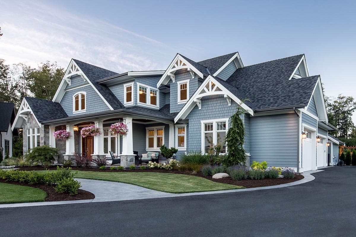 House plan exterior, Craftsman style, two stories, prominent gables, wide porch with white columns, and a three-car garage.