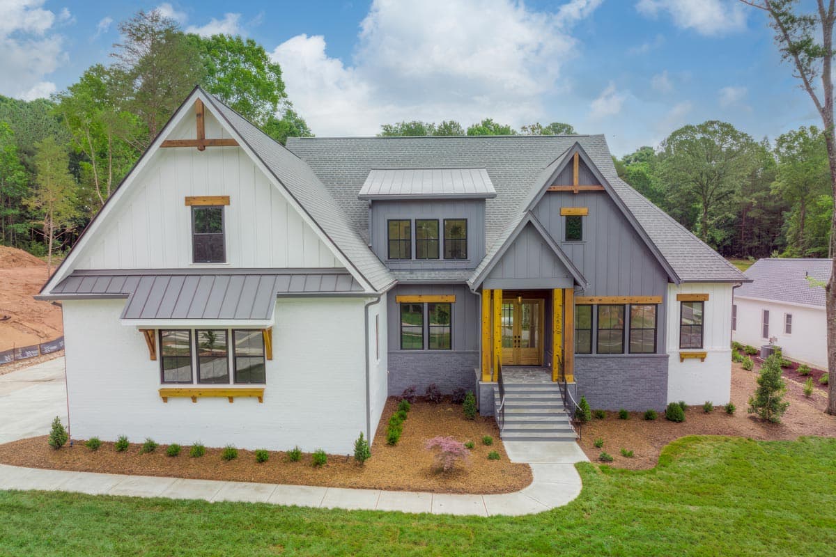 Modern Farmhouse house plan exterior with gables, metal awnings, wood accents, and prominent entrance.
