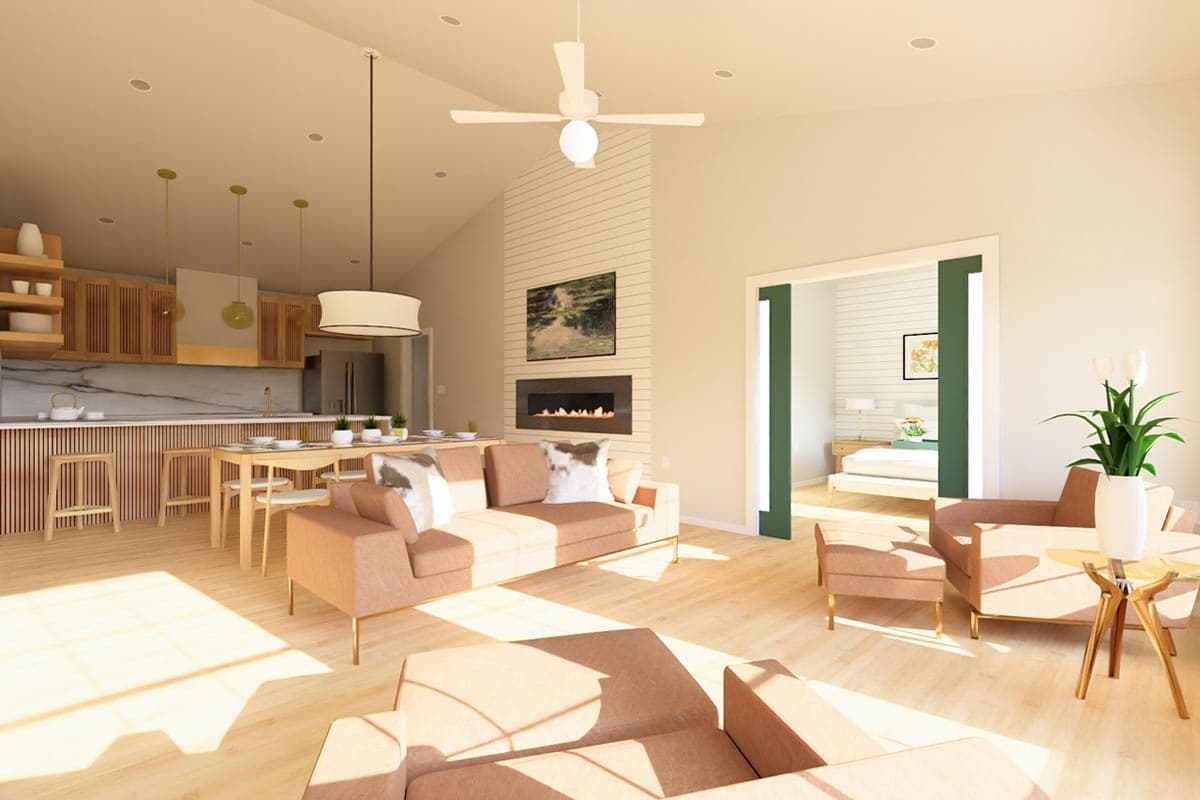 Open-concept living space with vaulted ceiling, modern fireplace, kitchen island, dining area, and a view into a bedroom.