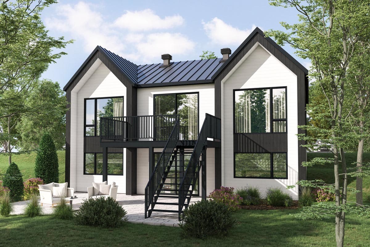 House plan exterior. Two-story modern style home with gable roof, exterior stairwell, and balcony with black railing, overlooking a patio.