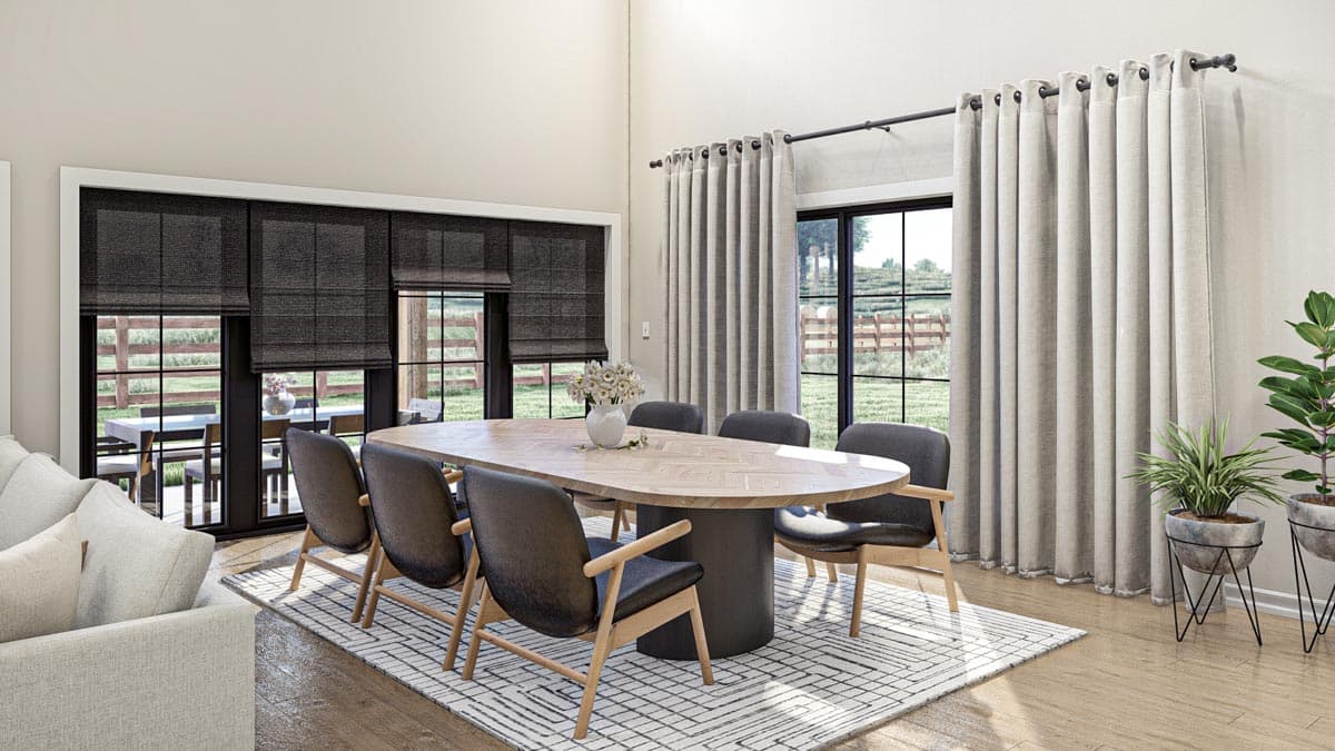 Dining room with oval table, seating for eight, vaulted ceiling, large windows, and patio doors.