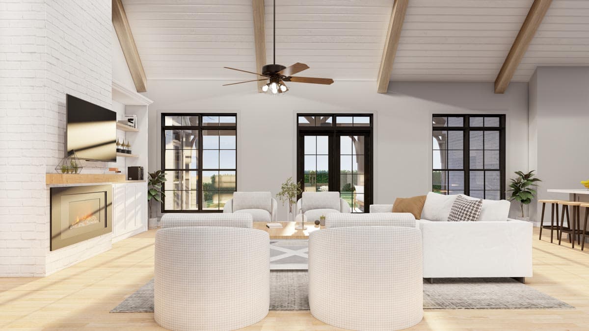 Great room with vaulted beamed ceiling, fireplace, and large windows.