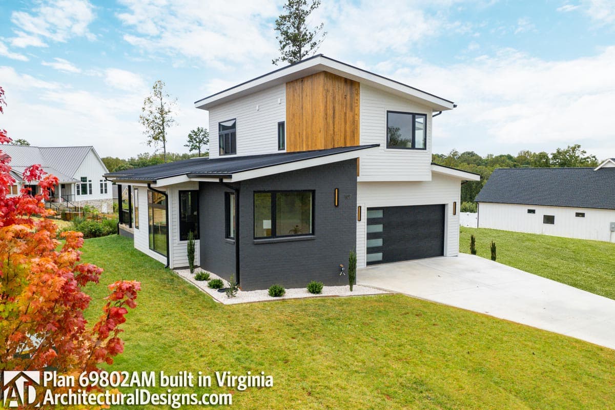 Two-story modern house plan exterior with white siding, wood accent, black brick, and a two-car garage.