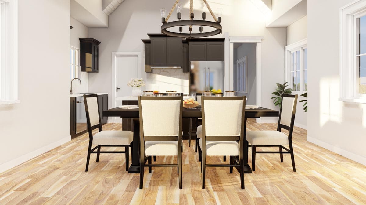 Dining area with dark wood table and upholstered chairs, adjacent to kitchen with dark cabinetry and stainless steel refrigerator.