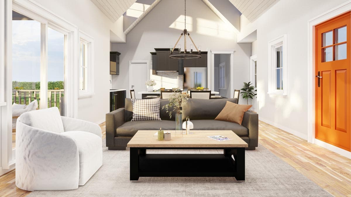 House plan interior showing living area with vaulted ceiling, sofa, armchair, kitchen, and dining space.