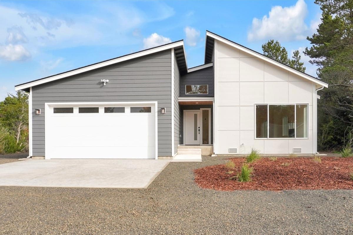 Modern house plan exterior with a white garage door, asymmetrical rooflines, and a split facade featuring gray siding and white paneling.