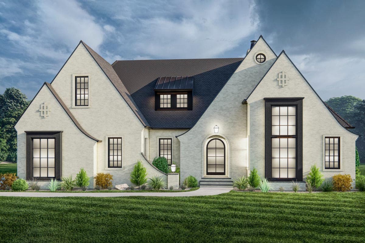 House plan exterior with arched entry, gabled rooflines, and multi-paned windows. Features brick facade and decorative dormers.