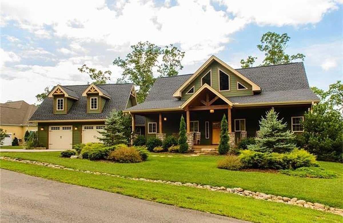 House plan exterior: Two-story dwelling with attached two-car garage, covered front porch, gables, and dormers.