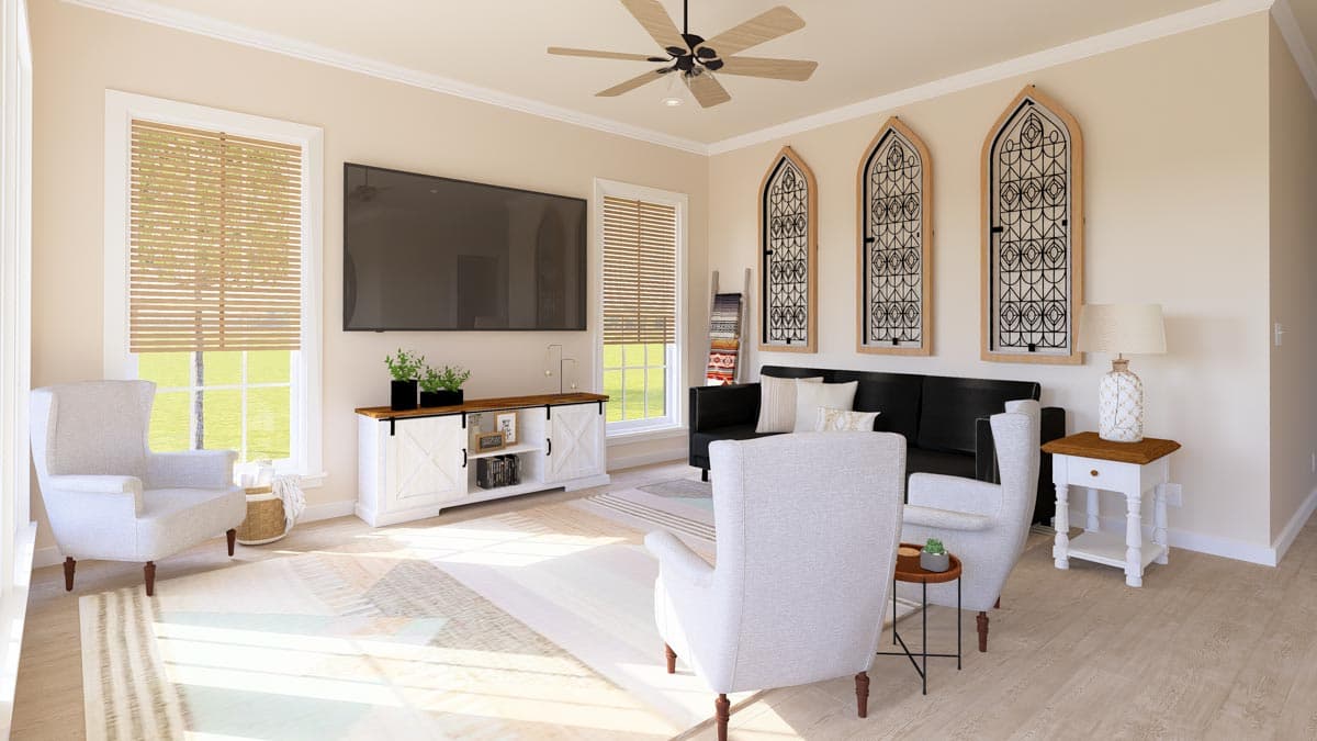 Living room with black sofa, light gray chairs, white media console, and decorative arched window panels.