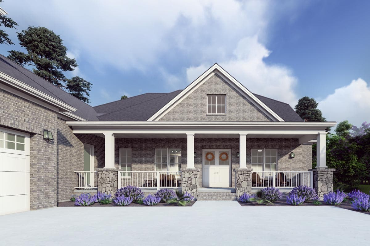 House plan exterior: Brick home with a gabled dormer, covered porch with stone-accented columns, and a two-car garage.