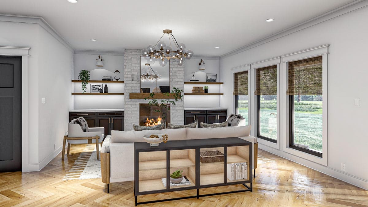 Living room with brick fireplace, built-in shelving, and large windows. Open layout with modern furnishings.
