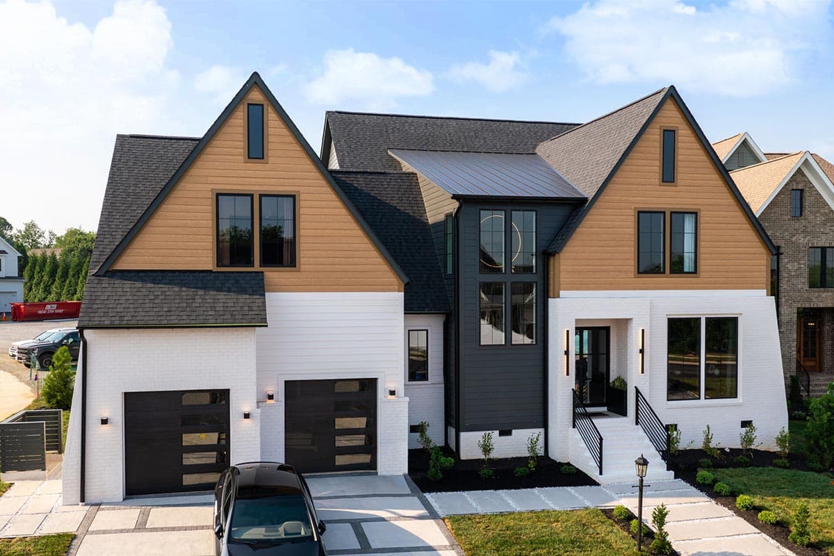 House plan exterior with Modern Farmhouse style, white brick, wood siding, gables, and a metal roof.