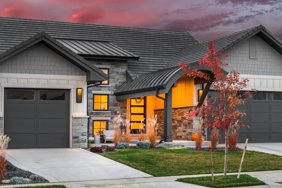 House plan exterior: Modern style with stone and shingle siding, two garage doors, gabled roofs, and arched entry.