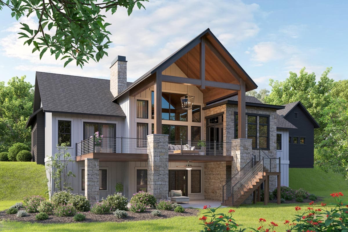 Modern Farmhouse house plan exterior with stone accents, prominent gables, a two-story great room with expansive windows, and a covered deck.