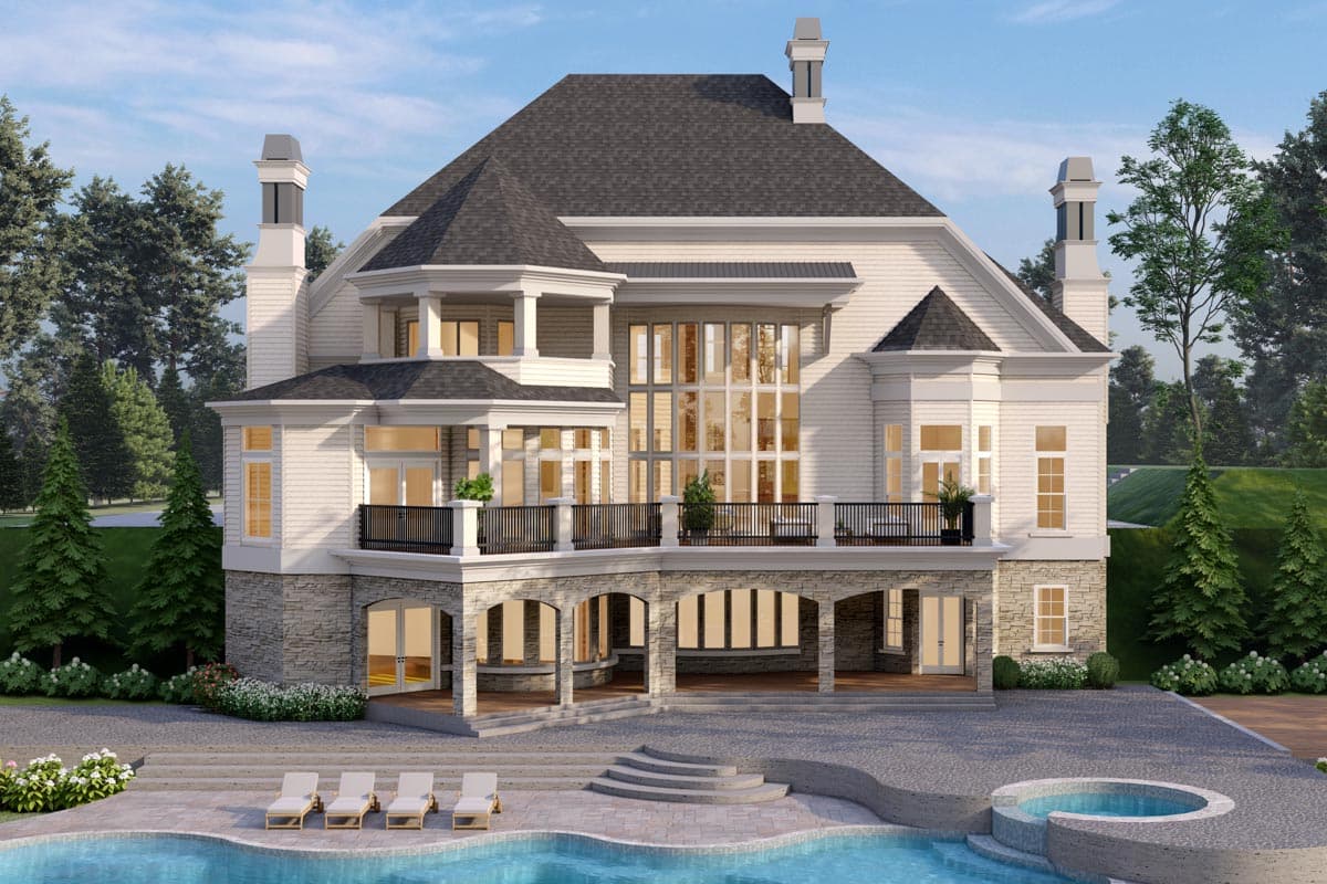 House plan exterior: large two-story home with stone accents, multiple gables, wrap-around balcony, and grand windows.