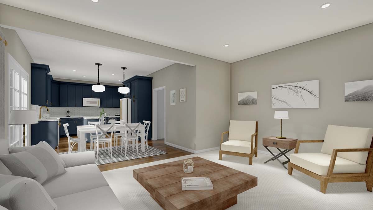 Open concept living area with sofa and chairs connected to a kitchen with navy cabinets and white dining set.