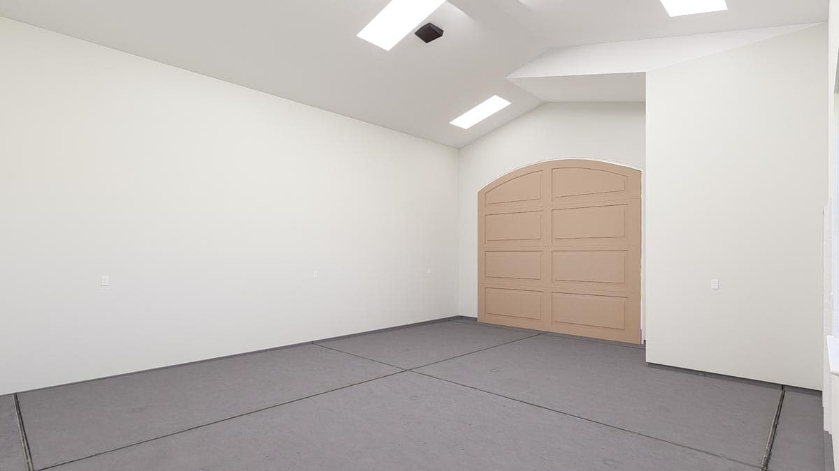 Garage interior with arched carriage-style door, skylights, and segmented concrete floor.