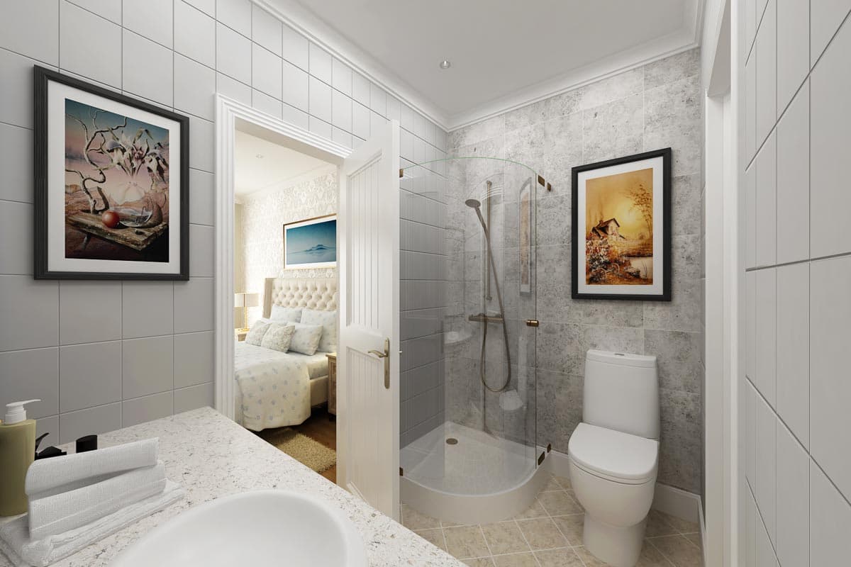 Bathroom interior with curved glass shower stall, toilet, vanity countertop, and view into bedroom with tufted headboard bed.