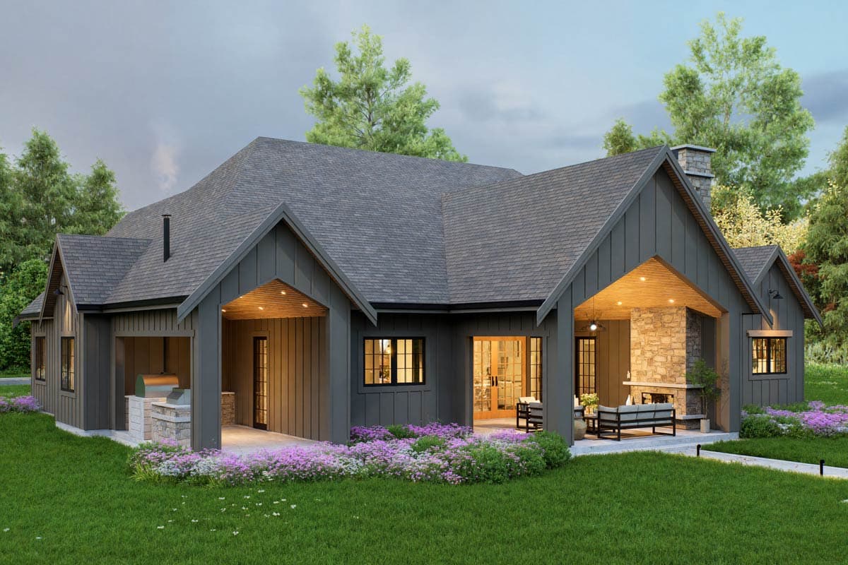 House plan exterior: Ranch-style, dark siding, gabled rooflines, covered porch with stone fireplace, and outdoor kitchen.