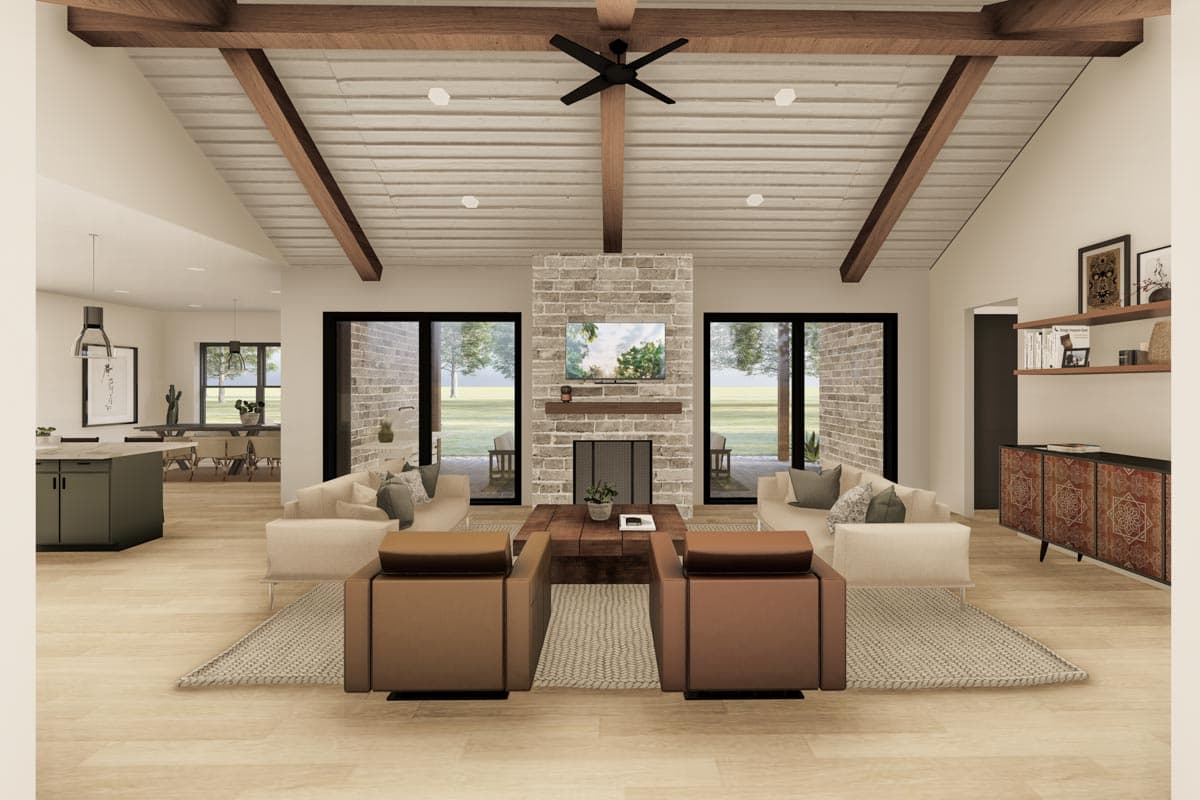 Living room with vaulted ceiling, exposed beams, stone fireplace, and large glass doors.