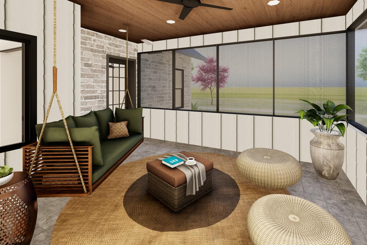 Screened porch interior with hanging daybed, ottoman coffee table, woven poufs, and large windows overlooking a lawn.