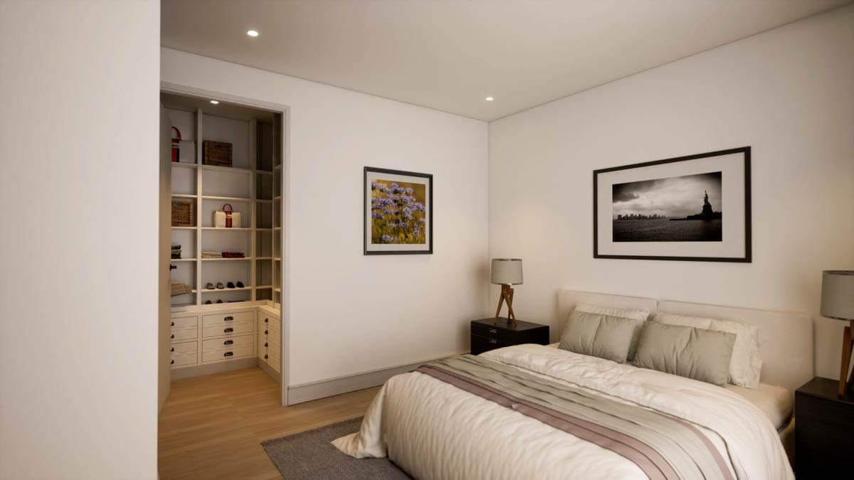 A modern bedroom features a bed with grey bedding, artwork on the walls, and a walk-in closet with shelves and drawers.