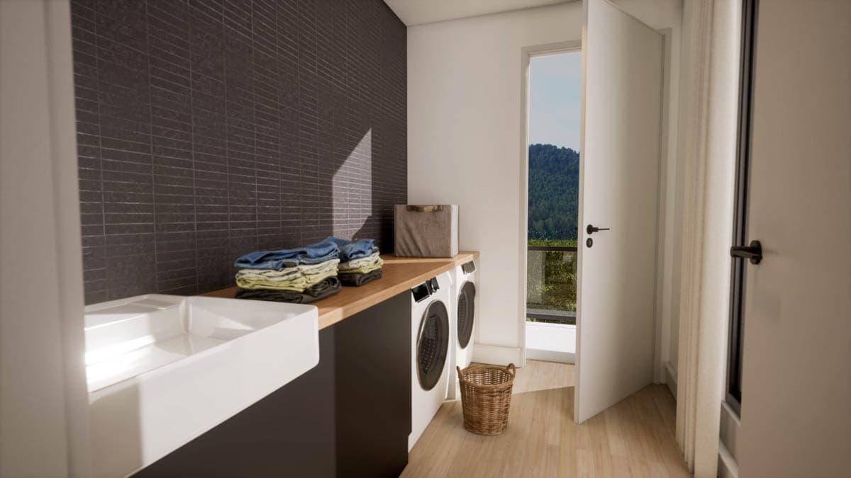 A modern laundry room with white appliances, wooden counter, and a view of a lush green hillside through an open door.