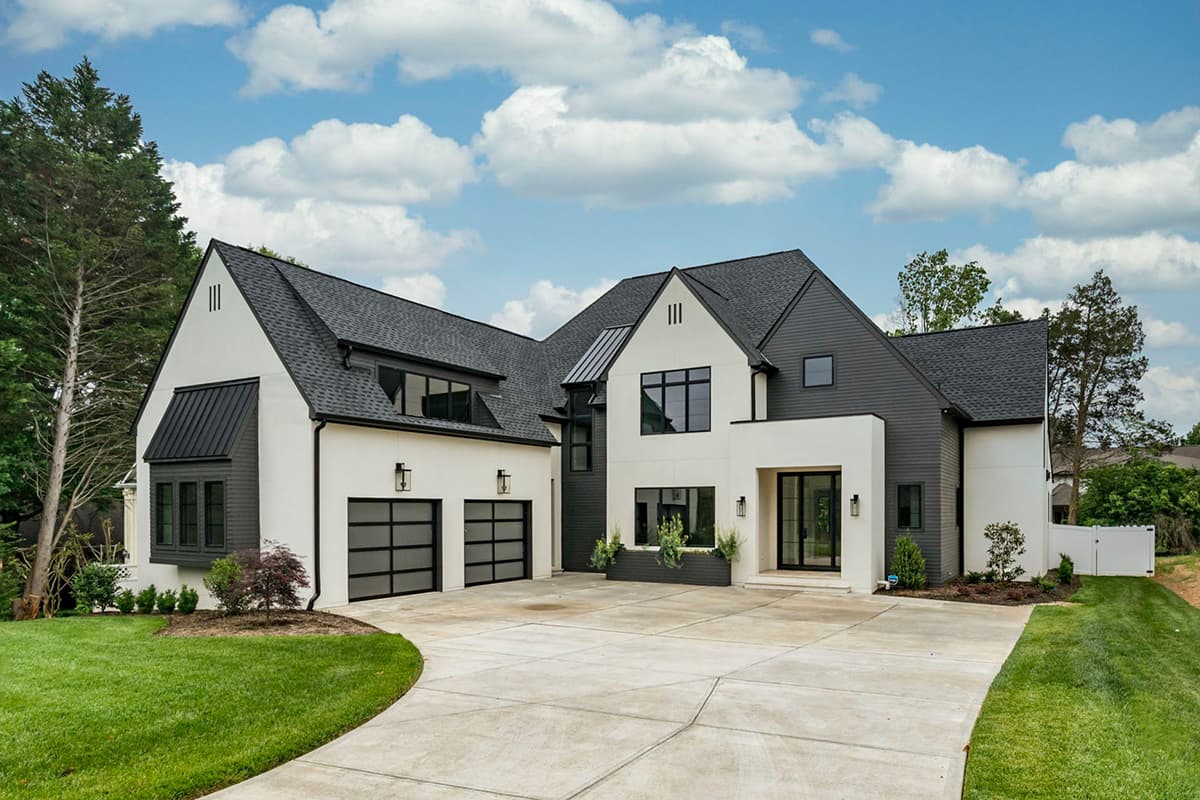 House plan exterior. Two-story modern house with a mix of siding and stucco, featuring a two-car garage, multiple gables, and large windows.