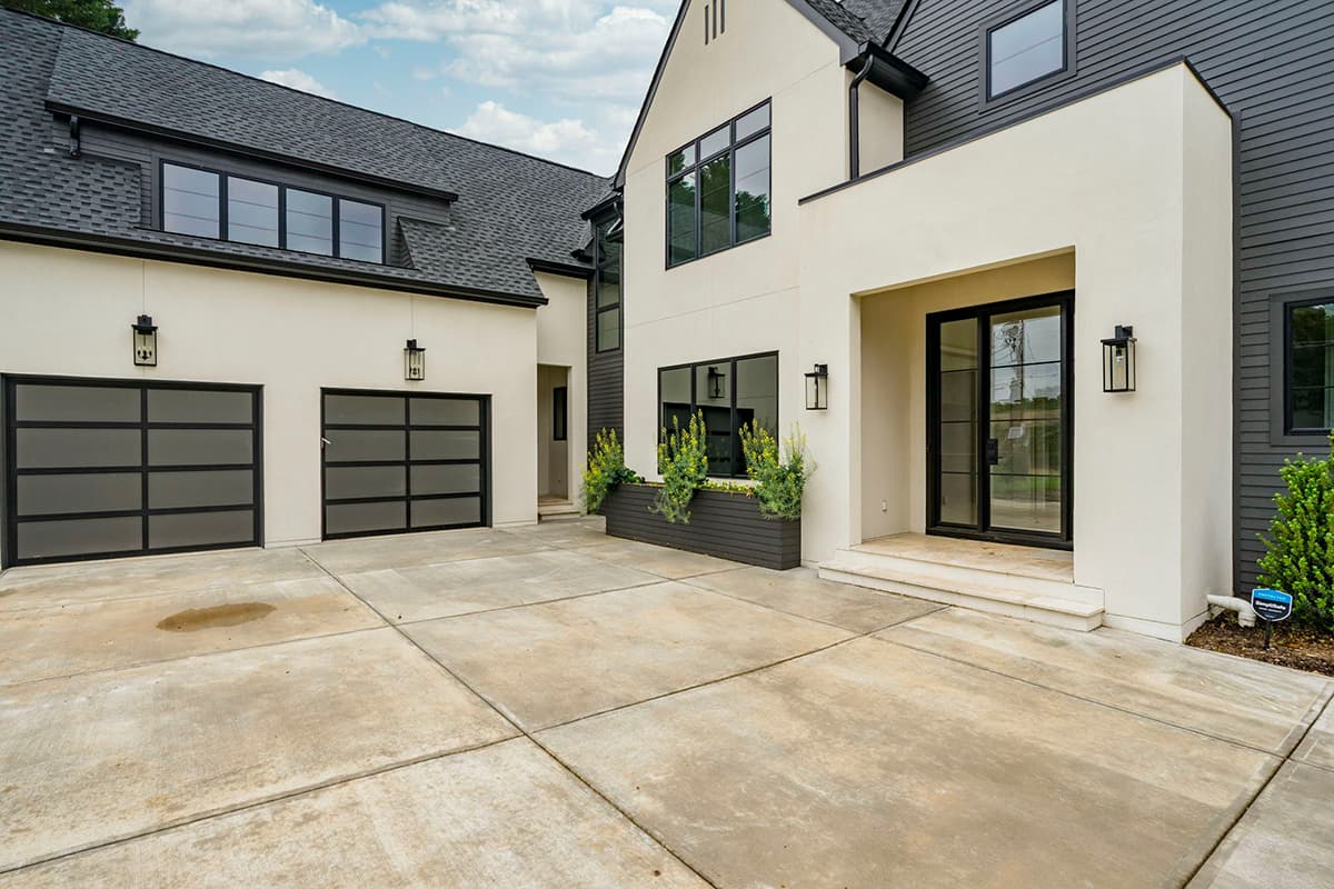 Modern house plan exterior with stucco and siding, two glass garage doors, and a covered entry with glass doors.