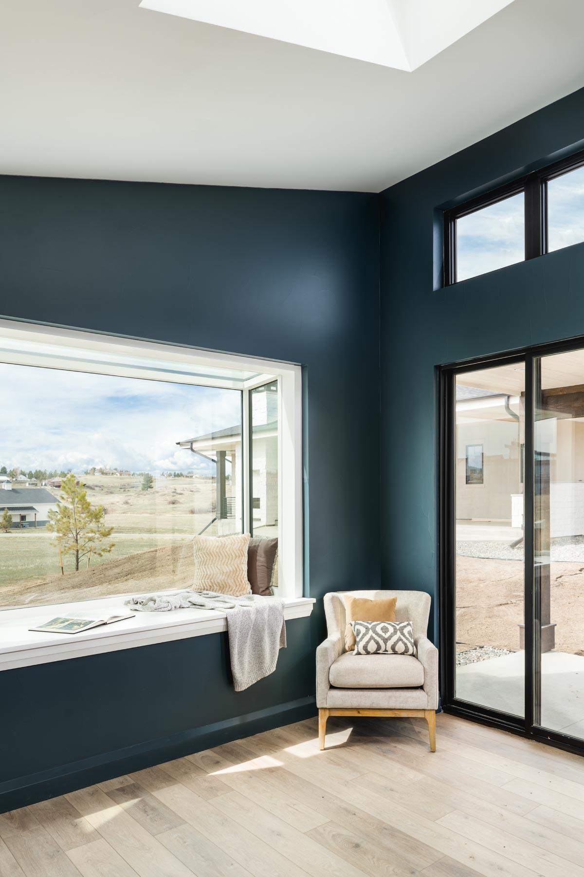 Interior view showing a corner with a large bay window, a chair, and a sliding glass door.